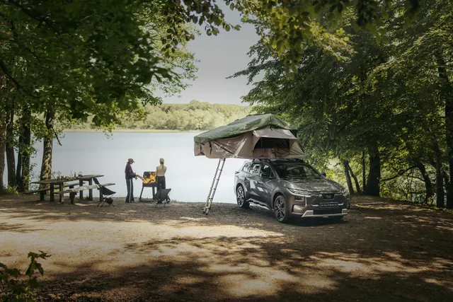 Subaru e-Outback med taktält och campingutrustning vid vattnet